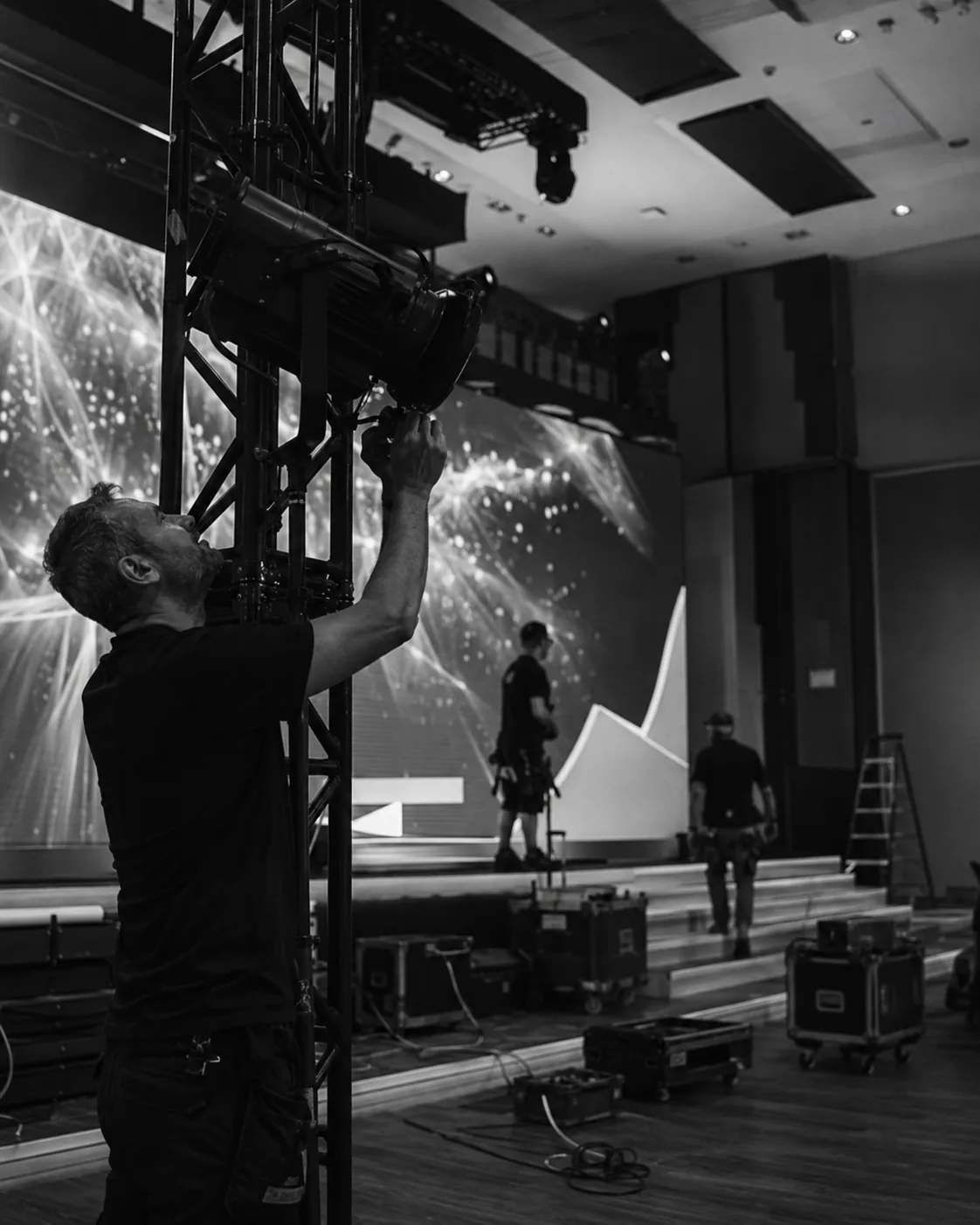 Técnico ajustando la iluminación y el montaje de un escenario