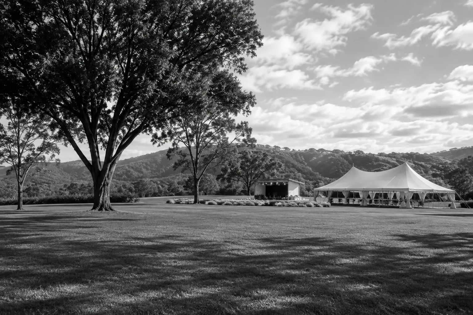 Terreno campestre con carpa y escenario para un evento al aire libre